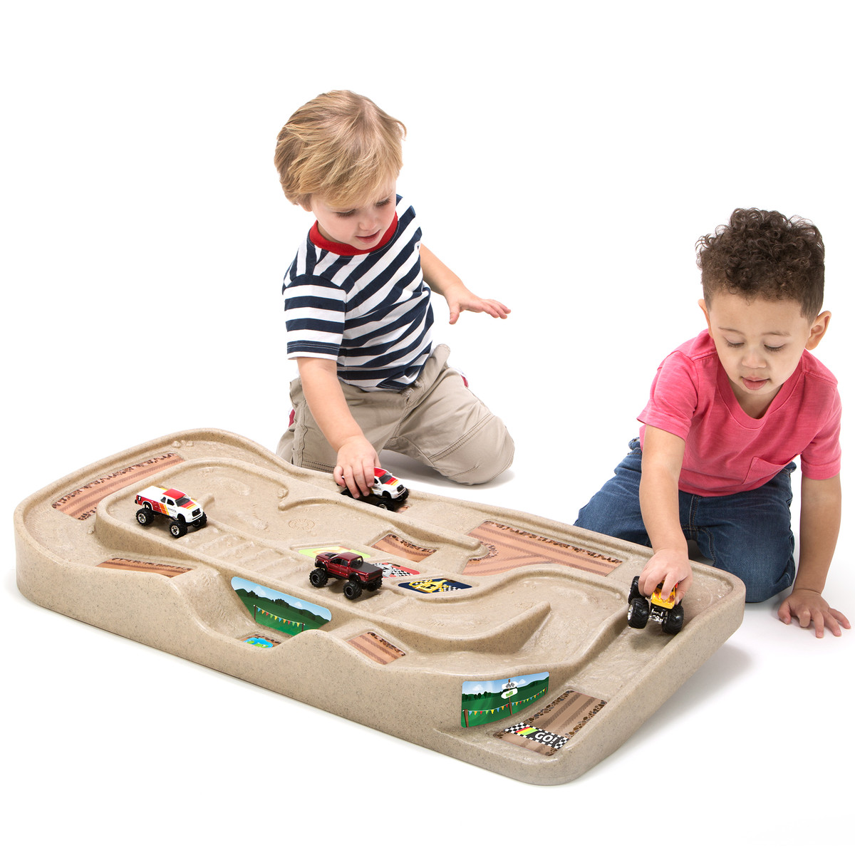Two toddler boys playing with monster trucks on Simplay3 Carry and Go Track Table