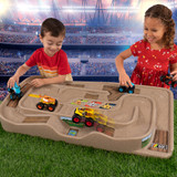 Two children playing monster trucks on the Carry and Go Track Table