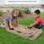 Two children playing monster trucks on the Carry and Go Track Table outside