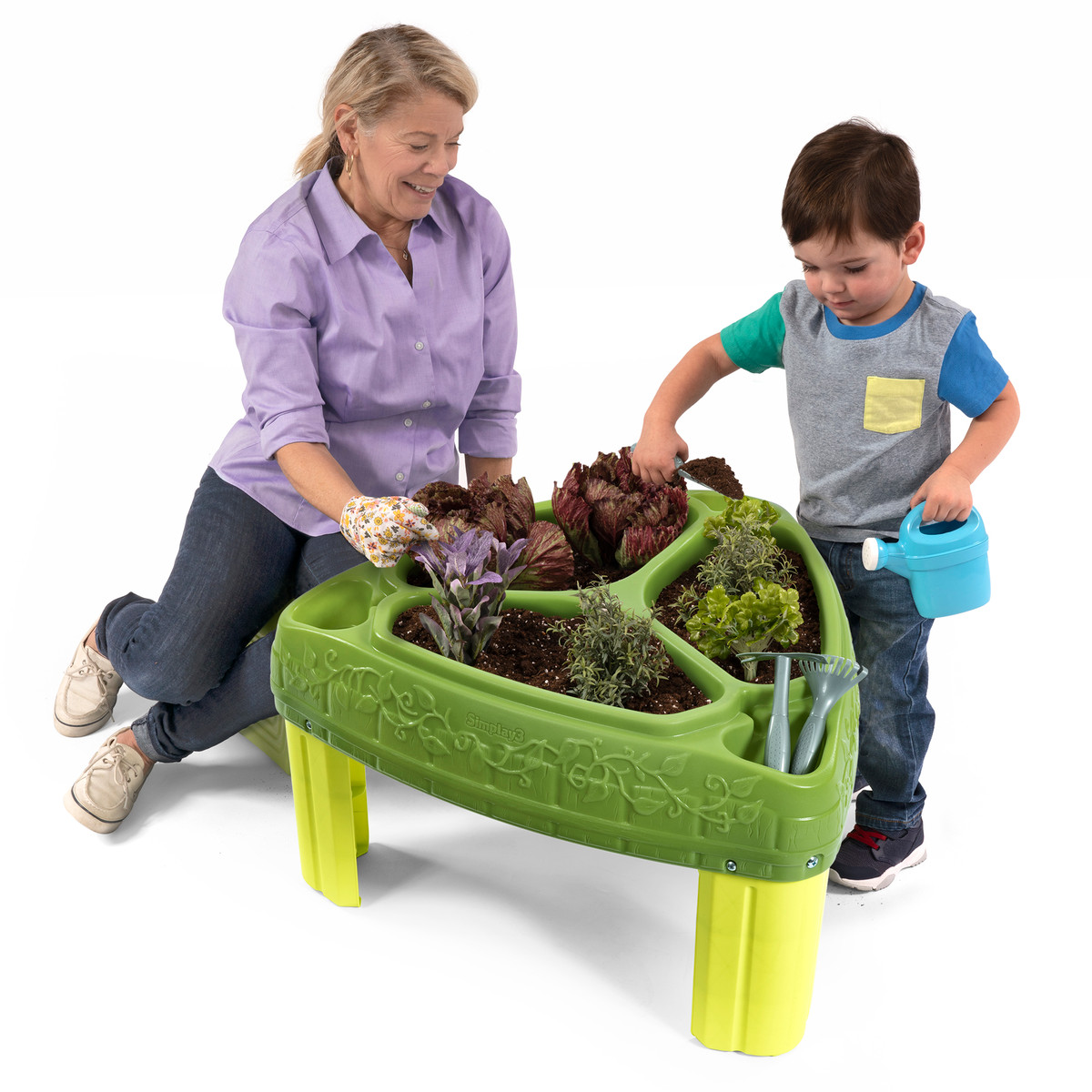 Young boy and caregiver gardening in the Seed to Sprout Raised Garden