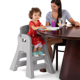 Simplay3 Big Kid Booster Chair with girl and adult at table
